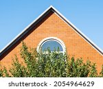 front view of brick gable wall of country house and blue sky on sunny day