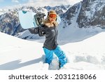 Portrait of beautiful snowboarder female going to freeride in winter mountain high. Sunny winter holiday, winter sport outdoor concept