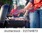 Tailgating: Man Grilling Sausages And Other Food For Tailgate Party