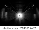 Small photo of Dreaming, man in dark tunnel. Freedom light in tunnel. Silhouetted desaturated. Silhouette of a woman walking into the light. Light at the end of the tunnel. business man in silhouette walking