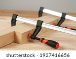 Iron clamps. Clamps and vices. Wooden bars on workshop table