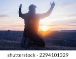 Small photo of Prayer. Repentance. A man on his knees. Prayer. Silhouette of a man on a blue sky background. Kneeling Prayer to God. Glorification. Praising God. Christian