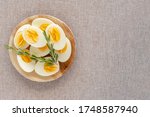 Top view of boiled eggs in wooden bowl on cotton fabric background with copy space. Boiled egg diet.