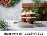 Christmas tree cupcakes. Chocolate cupcakes with whipped cream, sugar golden balls and snowflakes with holiday decorations behind the background. Copy space