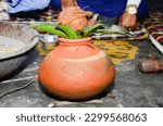 Small photo of Close up of a pot with coconut on the floor in a temple, Indian wedding ceremony decorative coper kalash with green leaf and coconut