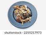 Small photo of fishbone,Bones or Scrap of food in the white plate after eating. Remains of fried fish. food scraps.