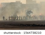 Military police riot line up response to a protest with tear gas, smoke, fire, explosions and police dogs. Political expression, riot, protest, demostration and military concept.