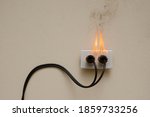 Small photo of On fire electric wire plug Receptacle on the concrete wall exposed concrete background with copy space