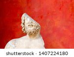 Fragment of a damaged antique sculpture against red background. Half a man. Incomplete or something missing concept. Copy space.