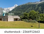 Small photo of Chamonix, Haute-Savoie, Auvergne-Rhone-Alpes, France - 07 27 2023: Exterior of the Richard Bozon swimming pool with the peak of the Aiguille du Dru (Mont Blanc massif) in the background in summer