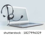 Laptop. Mockup screen and headphones on grey desk and plain background banner. Distant learning or working from home, online courses or support minimal concept. Helpdesk or call center headset