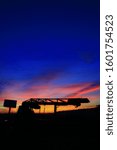 Small photo of Incredible very colorful sunset in the countryside. Silhouette of an industrial agricultural machine against the day. Cumulonimbus and stratus in a beautiful sky at night.