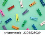 Colored wooden clothespins on mint background. Design elements. Macro. Space for text