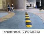 Yellow and Black Striped Speed Bump in residential area in family and pedestrian and granite pavement Background, Mid-Day