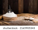 Organic Natural Whole Grain Flour in Sacks and wheat seeds Ears of wheat on an old wooden floor