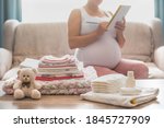 Pregnant woman is getting ready for the maternity hospital, packing baby stuff. pregnant woman preparing and planning baby clothes.  List of things in the hospital.  