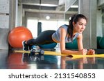 Healthy Asian athlete woman in sportswear do plank workout exercise body weight lifting at fitness gym. Strong female body building muscle weight training at sport club. Health care motivation concept