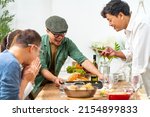 Small photo of Group of Asian people friends enjoy dinner party eating food and drinking wine on the table with talking together at home. Happy man and woman reunion dinner meeting celebration on holiday vacation