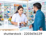Small photo of Confident Indian woman pharmacist medication recommendation about medicine, drugs and supplements to male patient customer in modern drugstore. Medical pharmacy and healthcare providers concept.