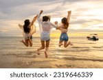 Group of Young Asian woman friends walking and playing together in the sea at tropical island beach at summer sunset. Attractive girl enjoy and fun outdoor lifestyle travel nature on holiday vacation.