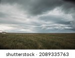 Beautiful icelandic landscape with dried grasses of fall and harsh stormy moody sky