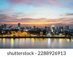 Small photo of The golden afterglow over Cambodia's capital city,it's busy Riverside and famous landmarks and the Royal Palace,as the setting sun sinks from behind the Tonle Sap river.