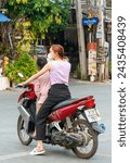 Small photo of Mae Hong Son province,Northern Thailand-April 10 2023:A strange sight to see,perhaps,in Western countries.But in Asia the motorcycle is a popular way of transporting multiple people,pets and goods.
