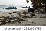 Small photo of Dirty sandy beach by fishing boats in Maldives, lots of thrash and plastic bottles around. Environmental pollution concept