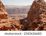 Small photo of Jordan, Petra, Narrow road to Ad Deir monastery. Blurred background. Selective focus. Mountain landscapes with steep abysses. Road between rocks going up. Rocky rocks of red, pink and orange tones.