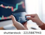 Closeup graph - Woman is checking Bitcoin price chart on digital exchange on smartphone, cryptocurrency future price action prediction.