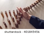 Businesswoman hand stopping the domino wooden effect concept for business.