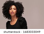 Beautiful african american woman looking at camera. Portrait of cheerful young woman with afro hairstyle. Beauty girl with curly hair.