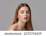 Small photo of Studio beauty portrait of very natural woman with freckles on her face. Girl looking at the camera. A lot of copy space. Skin care concept. Ideal, delicate makeup.