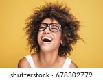 Young beautiful african american girl with an afro hairstyle. Attractive girl wearing eyeglasses. Portrait. Yellow background. 