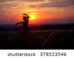 Young woman dancing alone in a field during sunset. Dancing silhouette of a young girl with sunset background.
