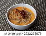 Small photo of A bowl of shamu datshi with is a dish of cheesy mushrooms.
