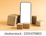 Smartphone with blank screen and cardboard boxes with copy space on yellow background. Cyber monday, cyber shopping, retail, technology, electronic device and communication concept.