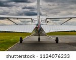 Symmetrical rear view of Cessna 172 Skyhawk 2 airplane on a runway with dramatic sky background.