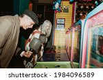 Small photo of Happy senior couple playing whack a mole at a game arcade