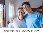 Small photo of Portrait of middle age mother spend time with teenager son, relatives people hugging at home, adult attentive millennial grateful child wrapped in a plaid or warm sweater loving mommy caring