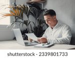 Small photo of Excited business man student reading postal mail letter overjoyed by great news, happy male winner holding paper bill with loan approval celebrate taxes refund receive salary rise payment sit at desk