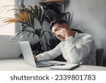 Small photo of Stressed tired man in pain having strong terrible headache attack after computer laptop work, fatigued exhausted guy suffering from chronic migraine massaging temples to relieve head ache tension