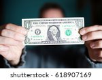 A Man Holds A U.s. 1 One Dollar.