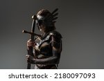 Shot of dramatic female warrior with sword dressed in steel armor posing agianst grey background.