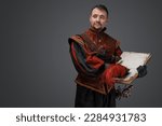 Small photo of Portrait of musketeer duelist dressed in stylish suit holding book looking at camera.