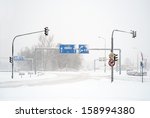 Empty winter road with traffic signs in snow storm