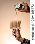Small photo of male hand holds vintage talcum brush and pours talcum powder from a bottle. Barber shop tools