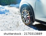 Car wheel with winter chains for snow and ice road on it close-up image
