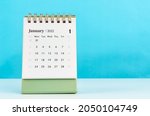 January 2022 desk calendar on blue background.