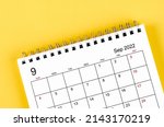 Close-up September 2022 desk calendar on yellow background.